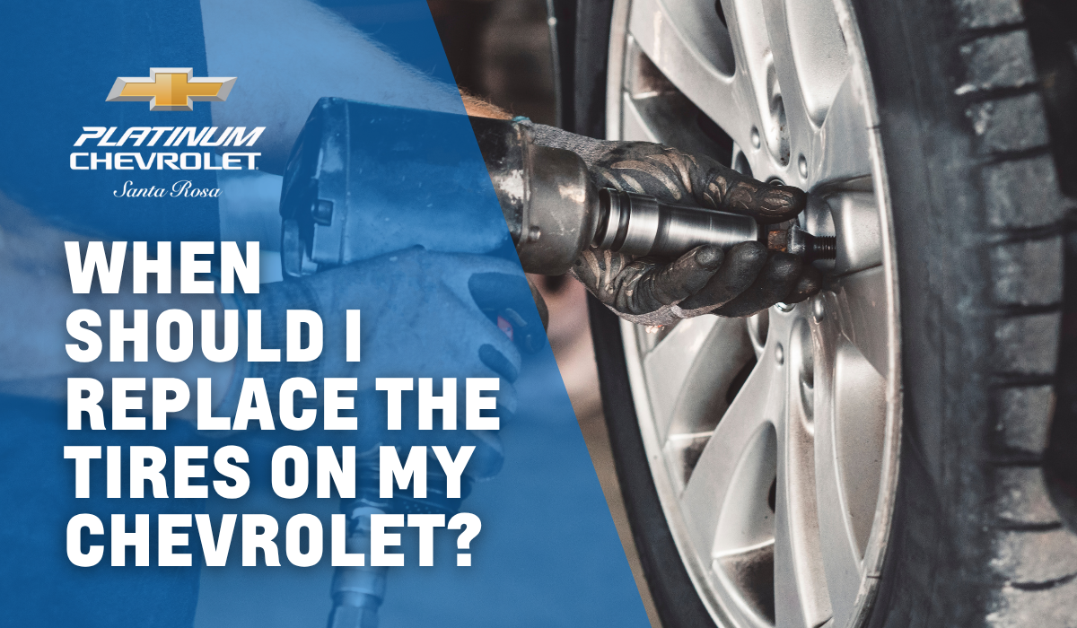 Technician replacing a Chevrolet tire using a power tool at Platinum Chevrolet Santa Rosa.
